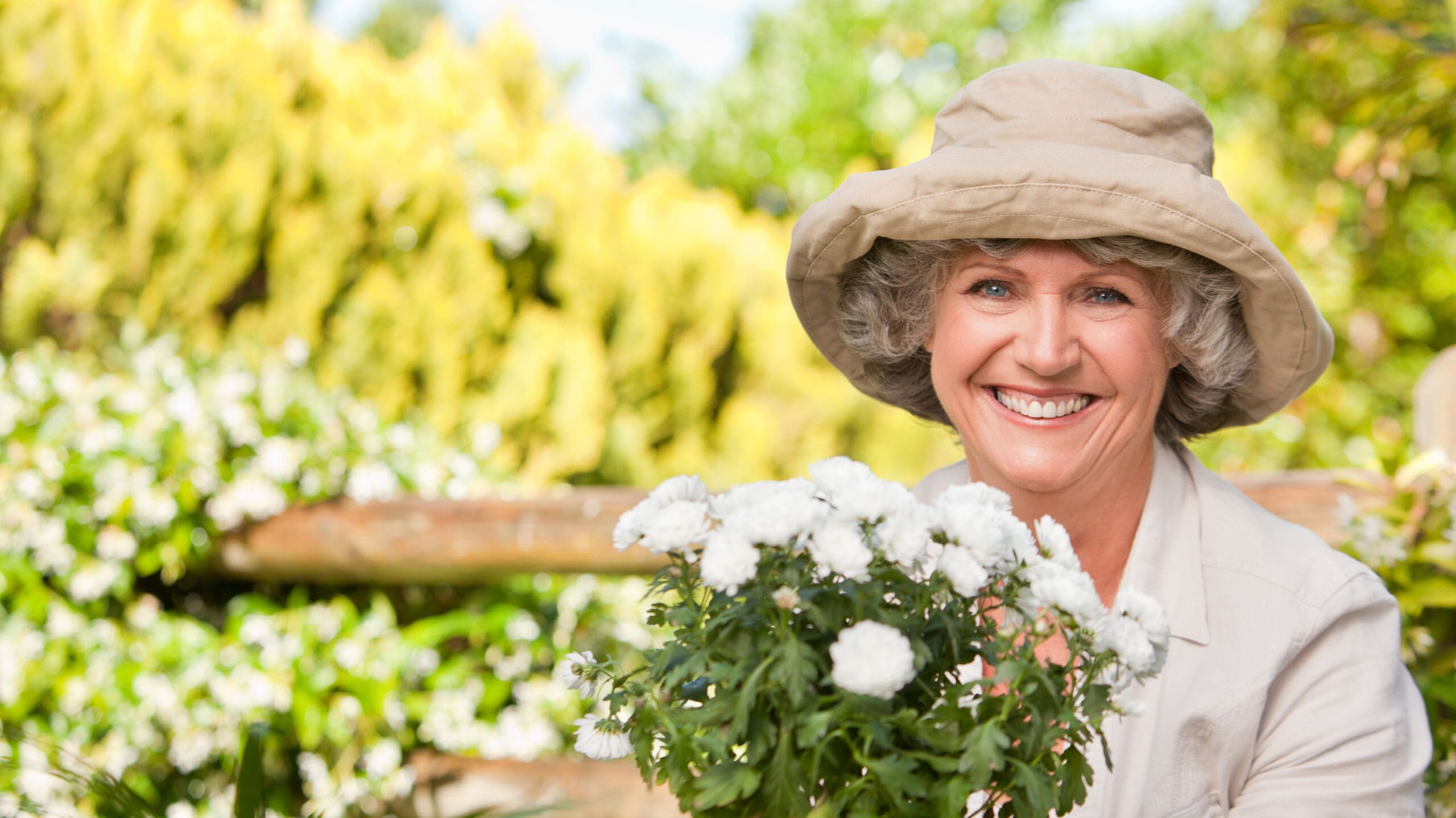 Senior woman smiling with flowers in her hands